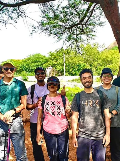 A group of trekkers under a tree, ready for their hike. This shows the start of another great adventure with a new group of friends.