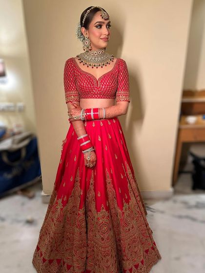 The complete look, showing how the modern makeup with bronze eyes perfectly complements the classic red lehenga and traditional jewelry.