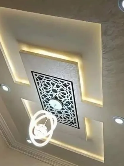 A sophisticated design that combines a modern recessed ceiling with a traditional backlit jali panel. This fusion of styles creates a unique and elegant focal point.