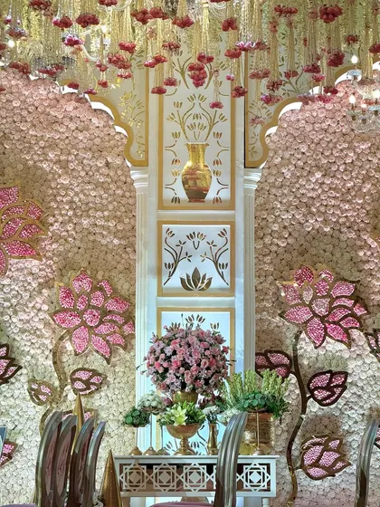 A close-up of the mandap's side panel, featuring hand-painted vase motifs and a backdrop of flowers. This highlights our commitment to custom, artistic details.