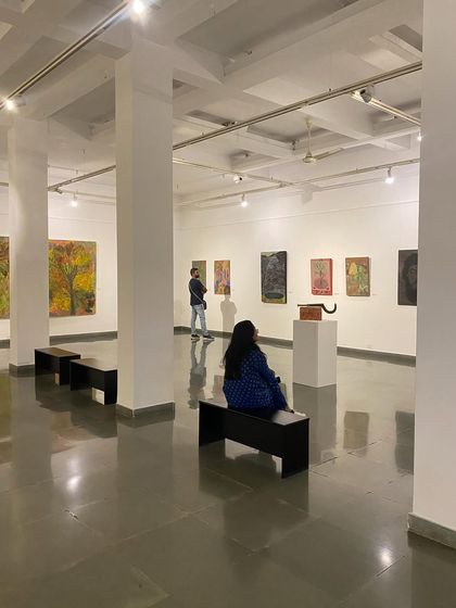 A quiet moment in the gallery with a visitor contemplating the art.