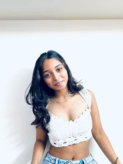 A portrait of me wearing my handmade white crochet crop top. It’s a piece I’m really proud of, combining intricate stitches with a modern design.