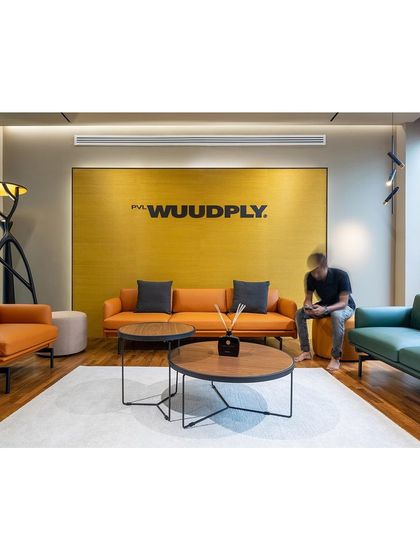 The reception and waiting area for Prime Ply uses the brand's signature color and comfortable, modern furniture to create a welcoming first impression for visitors.