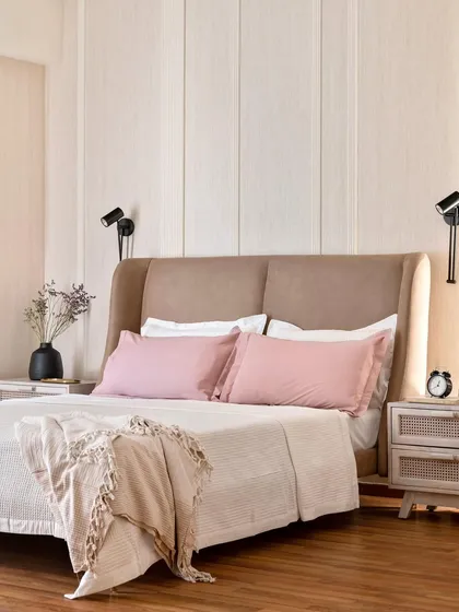 A bedroom should be a personal sanctuary for rest and calm. In this space, I used soft, neutral tones, a comfortable upholstered headboard, and fluted wall paneling to create a serene atmosphere, complemented by functional and stylish bedside lighting.