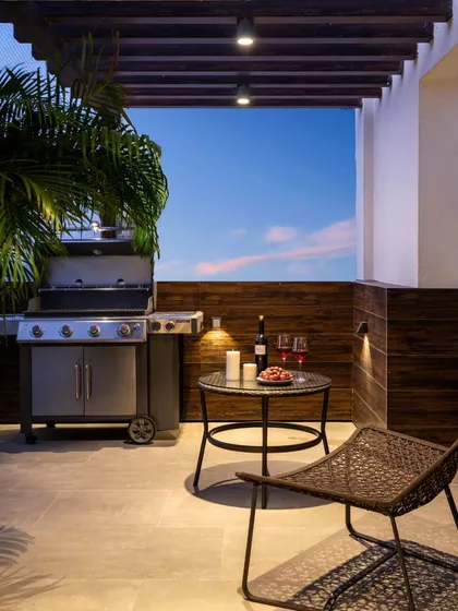 This terrace was designed for entertaining, featuring a dedicated BBQ corner perfect for evening cookouts. We used a dark wood-paneled privacy screen and a pergola structure to define the space, adding functional lighting to create a warm and inviting atmosphere after sunset.