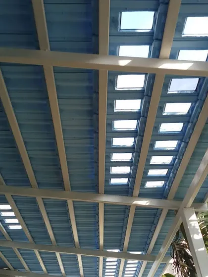A closer look at the blue Santorini-style pergola, showing how the skylight cutouts create a dynamic play of light and shadow on the space below.
