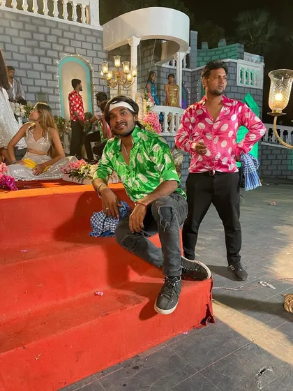 Taking a moment between takes on the set of a Bhojpuri music video. The costumes and grand sets are a big part of what makes these songs so visually appealing.