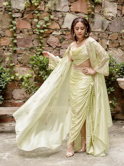 This lime green draped outfit by Punit Balanani on Nushrratt Bharuccha is perfect for a destination wedding. The cowl top and draped skirt create a chic, resort-style ethnic look.