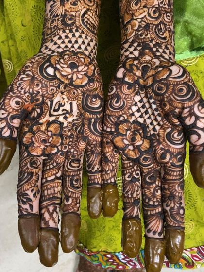 A beautiful floral bridal design with the groom's name, 'Fahad', elegantly placed in the center of the palm.