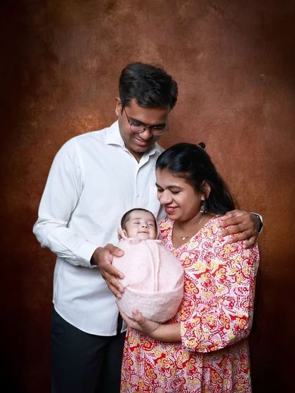 A smiling family portrait against a warm, painterly backdrop. We ensure everyone is comfortable, capturing the happiness and love of the entire family.