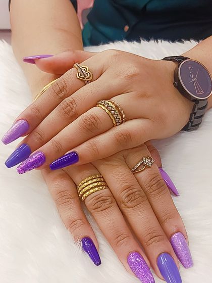 A color that speaks luxury and confidence. This set features a beautiful gradient of purple shades with glitter accents on long coffin-shaped nails.