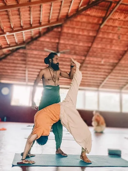 Nothing is impossible with the right guidance and dedication. I assist a student in a challenging one-legged downward dog split, showing that progress is always possible.