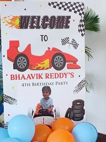 The welcome sign for the Hot Wheels birthday party, featuring a race car graphic and checkered flag details.