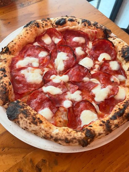 A classic pepperoni pizza, with its signature charred crust and melted mozzarella.