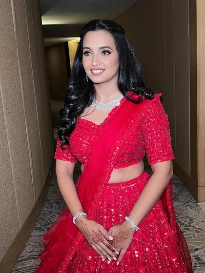 A full view of this client's radiant reception look. The soft glam makeup lets her happiness and beautiful red outfit be the focus.