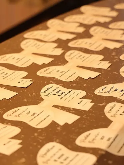 A close-up of the bow-shaped prediction cards, a beautiful and thematic detail that guests loved filling out.