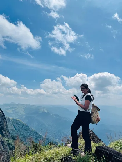 A trekker enjoying the panoramic view from the Kumara Parvatha trail on a clear day.