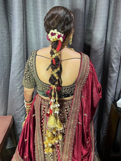 A detailed shot of a textured bridal braid with a traditional 'parandi'. This hairstyle is perfect for a Pahadi or Punjabi bride, blending tradition with modern styling.