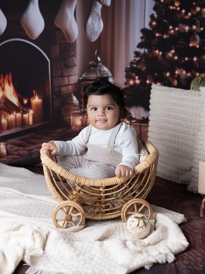 Another angle of our cozy Christmas fireplace setup. This little one looks so content and happy in his little cart, surrounded by the warm glow of the holiday scene.