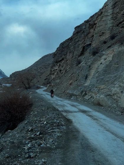 A lone biker on a rugged road in Spiti, embodying the spirit of adventure.