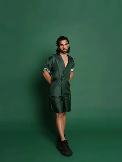 A full-length shot of Orry against the green backdrop, showcasing the complete look I put together for his GQ Best Dressed feature.