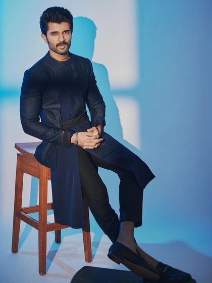 Seated, the interesting structure and drape of Vijay's outfit are clearly visible. It’s a great example of contemporary Indian design.