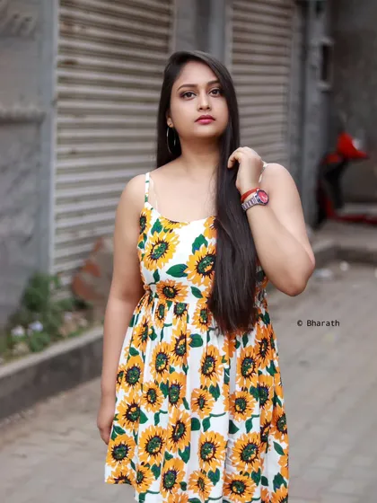 A standing portrait of the model in the sunflower dress against a closed metal shutter, creating an interesting textural contrast.