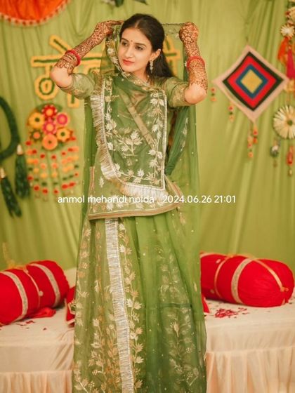 A candid shot of the bride adjusting her veil, giving a lovely view of the henna on her forearms.