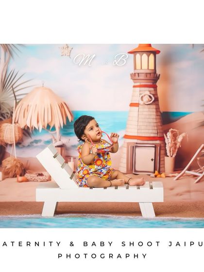 A stylish toddler posing on her beach lounge chair. The detailed backdrop with a parasol and lighthouse creates a perfect holiday vibe for this studio session.