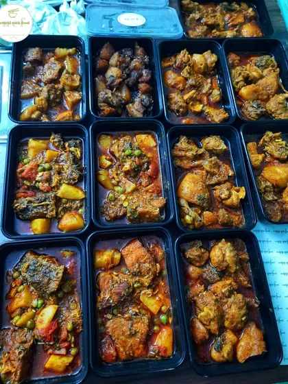 A variety of curries packed and ready for delivery, including fried fish curry, chicken curry, and pork.