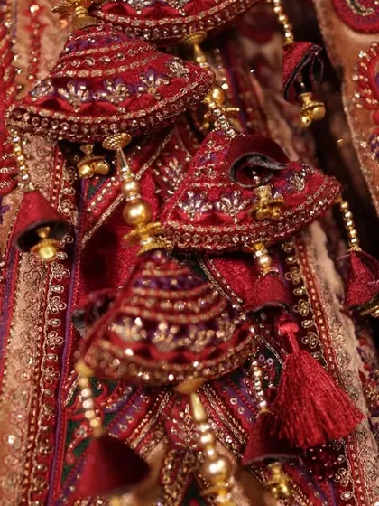 A close-up shot of the intricate tassels and embroidery on the bride's wedding lehenga, showcasing the craftsmanship of her attire.
