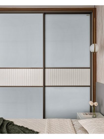 This custom-designed Aristo sliding door features a unique middle strip made from a laminated panel with linear grooves. This detail adds a layer of texture and sophistication to the wardrobe design.
