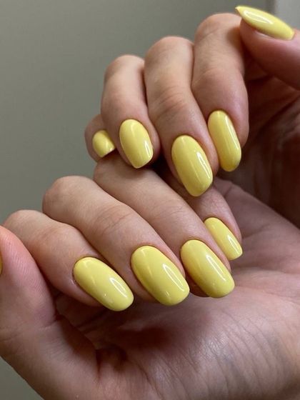 A bright and sunny yellow manicure. This cheerful color is applied flawlessly on these oval-shaped nails, perfect for making a happy statement.