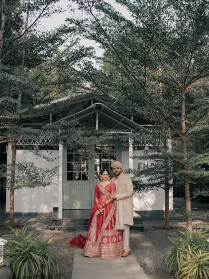 A full-length shot of a couple standing in front of one of our cottages. The architecture and surrounding trees create a charming, rustic backdrop for wedding portraits.