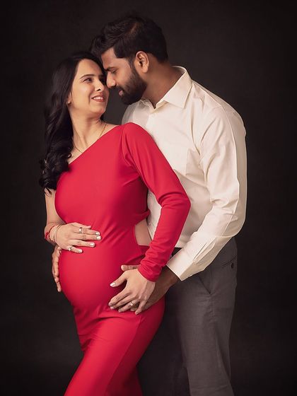 A classic pose showing the couple's loving connection. The simplicity of their outfits and the dark background create a timeless feel.