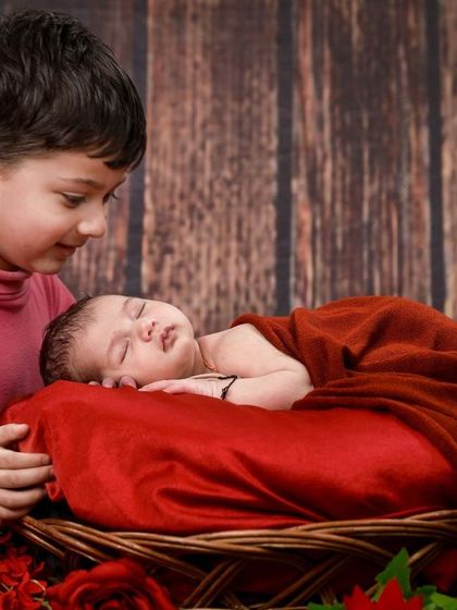 Another angle of the older brother watching over his sleeping newborn sibling, showcasing the protective and gentle bond between them.