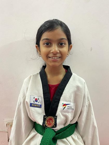 A portrait of a champion. This student's confident smile and medal show her pride in her achievement.