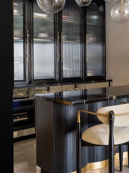 A stunning bar area designed by Studio Sylus, featuring our custom fluted and glass-fronted cabinetry. The design exudes a sophisticated, moody glamour.
