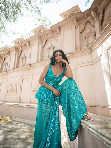 We make fashion fun. This teal sharara set with mirror work is a comfortable and stylish alternative to a lehenga, perfect for a wedding guest who wants to dance.