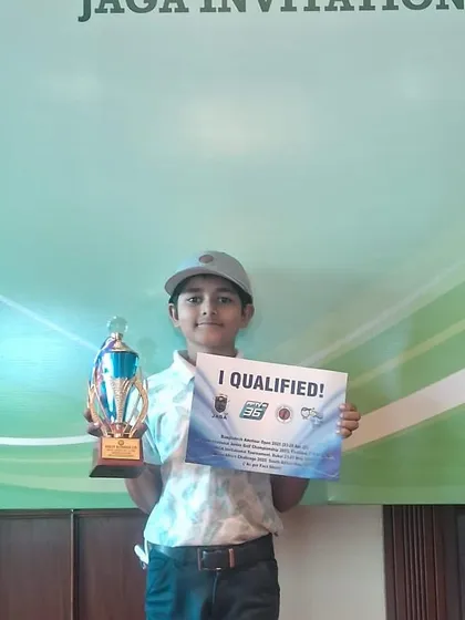 Taanush Kumar proudly holds his trophy and "I Qualified!" sign.