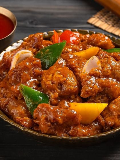A bowl of chili chicken, showcasing a fusion Indo-Chinese dish for Nazeer Foods' menu.