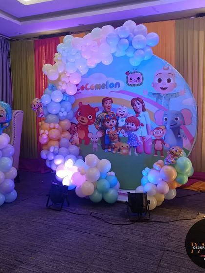 Another view of the Cocomelon birthday stage, showing the full setup with spotlights that enhance the colors of the decoration.
