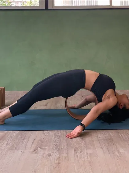 A student uses a yoga wheel to support a deep backbend, opening the entire front of the body. We have every prop you can imagine.