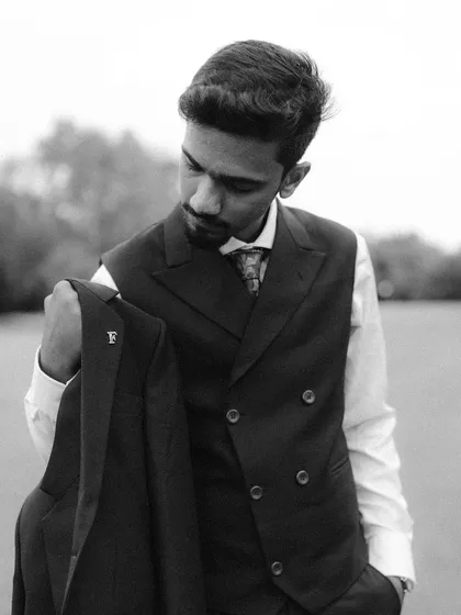 A classic black and white portrait of the groom, Aman. His sharp suit and thoughtful expression create a timeless and sophisticated look.