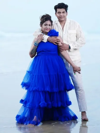 Plan the perfect beach photoshoot with my rental outfits. This vibrant blue tiered gown stands out beautifully against the sand and sea, and I have plenty of casual and formal options for men to create a coordinated couple's look.