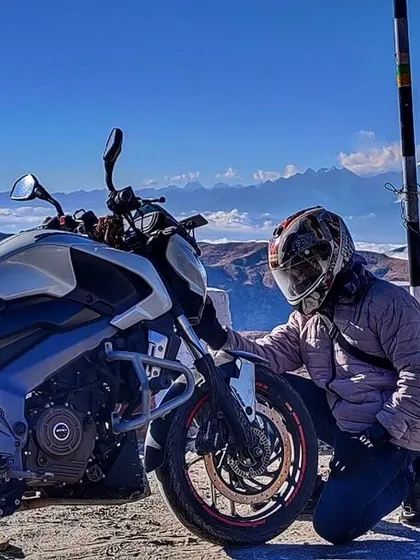 Paying respect to the machine that carries us through it all. Here's one of our riders with his Dominar at Nathang Valley, with the stunning Kanchenjunga range in the background during our Sikkim expedition.
