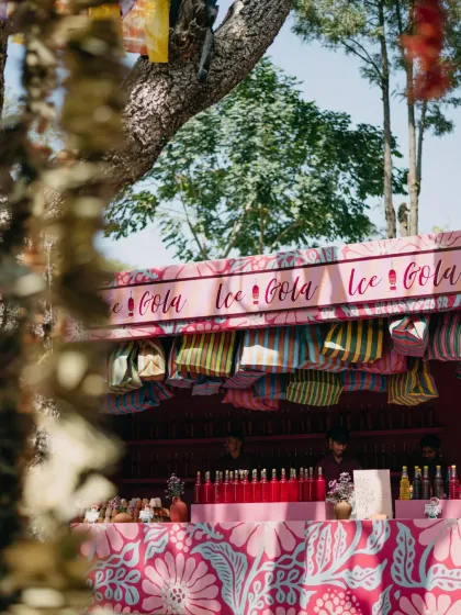 An "Ice Cola" bar with custom branding and colorful tote bags for guests. We design every element, from the drinks to the giveaways, to be part of the overall event theme.