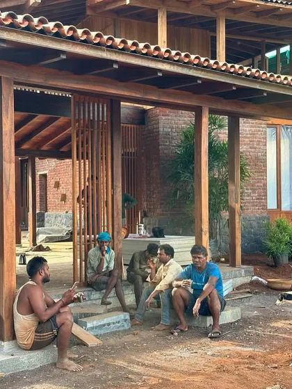 A group of artisans takes a well-deserved break on the steps of the farmhouse. The success of our projects relies on the skill and camaraderie of the entire construction team, who bring our designs to life.