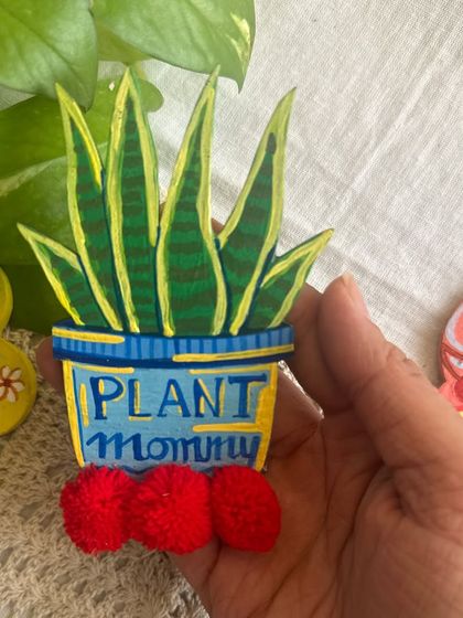 A close-up of the 'Plant Mommy' fridge magnet, a fun gift for anyone who loves their plants like children.