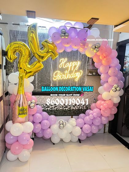 A 24th birthday celebration with a pastel ring decoration. The purple and pink balloons are paired with a champagne bottle prop and foil numbers.